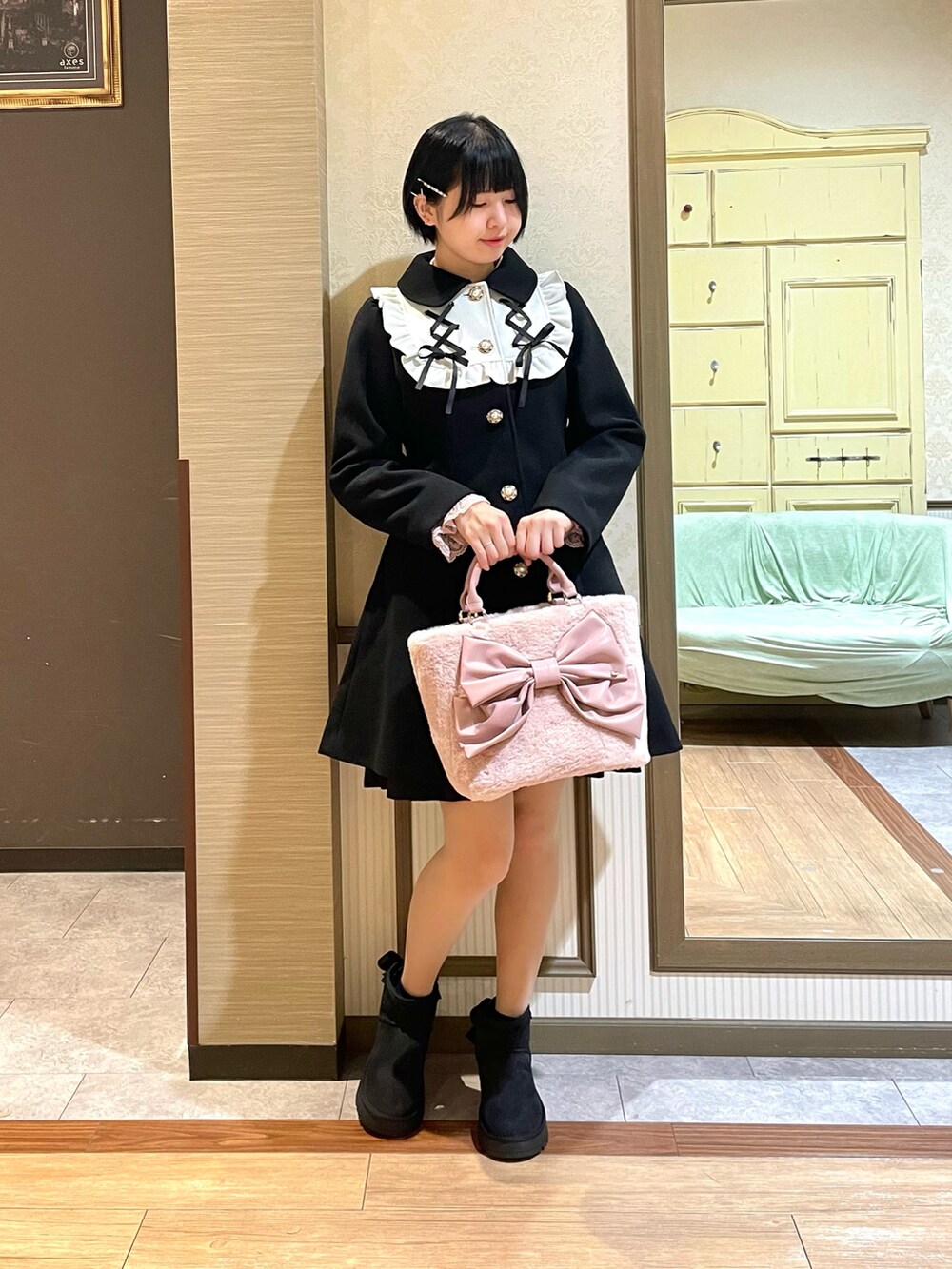 ピンク系のシャツ/ブラウス、ブラック系のワンピース、ブラック系のステンカラーコートを着用したレディースの秋コーディネートの2枚目の写真