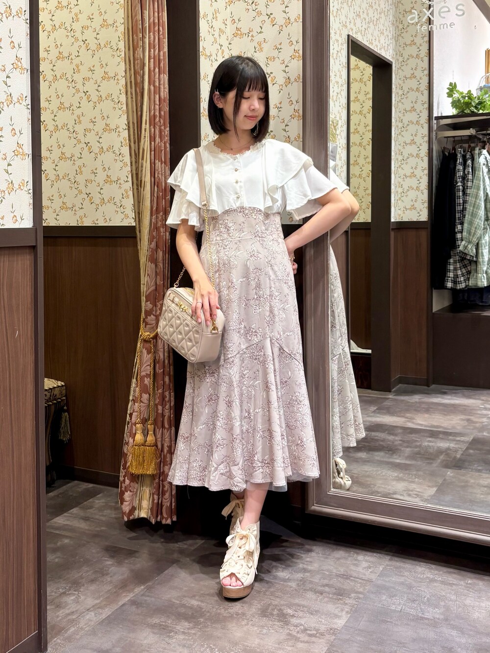 ベージュ系のワンピース、ホワイト系のタンクトップ、ベージュ系のショルダーバッグを着用したレディースの夏コーディネートの4枚目の写真