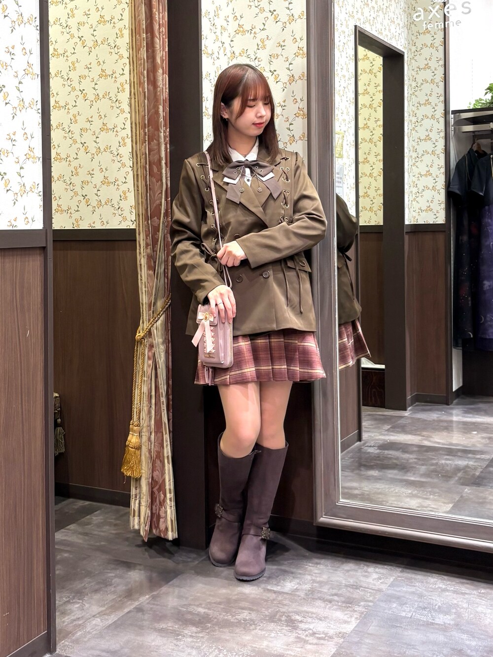 レッド系のベスト、ピンク系のその他パンツ、ブラウン系のブーツを着用したレディースの秋コーディネートの8枚目の写真