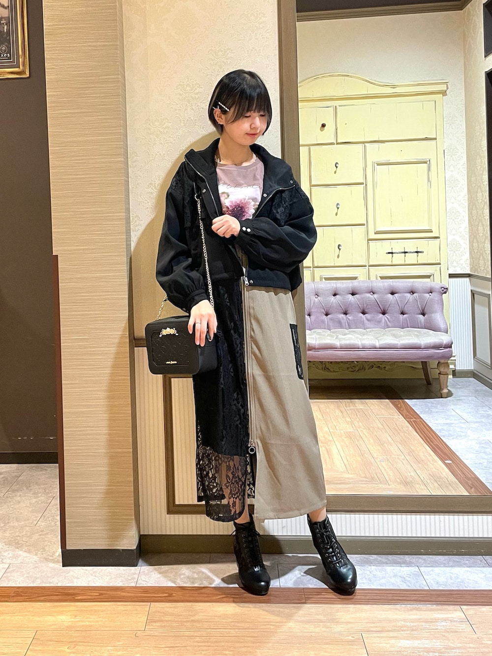 ベージュ系のスカート、ブラウン系のTシャツ/カットソー、ブラック系のブルゾンを着用したレディースの秋コーディネートの3枚目の写真