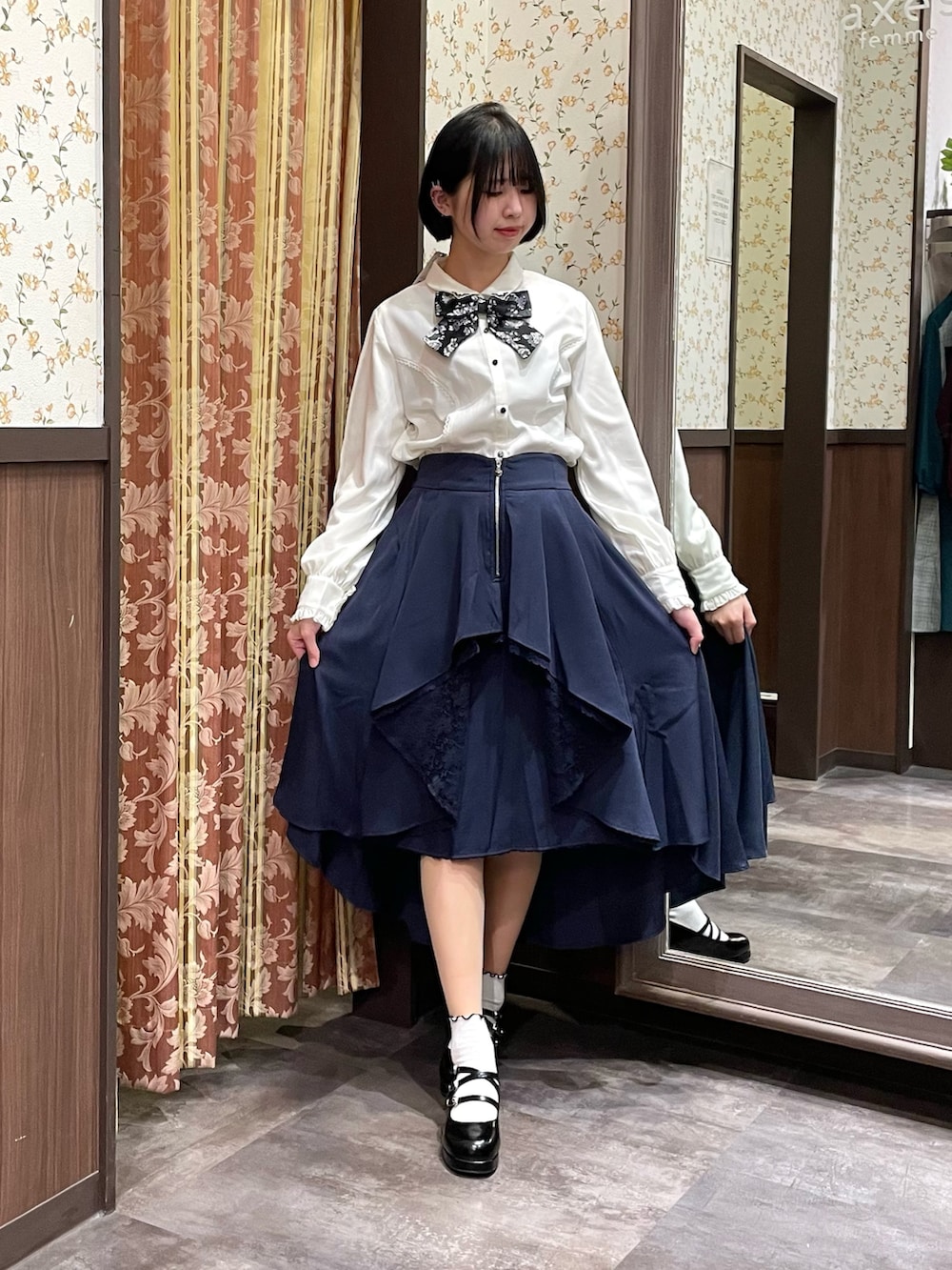 ホワイト系のシャツ/ブラウス、パープル系のカーディガン/ボレロ、ブルー系のスカートを着用したレディースの冬コーディネートの5枚目の写真