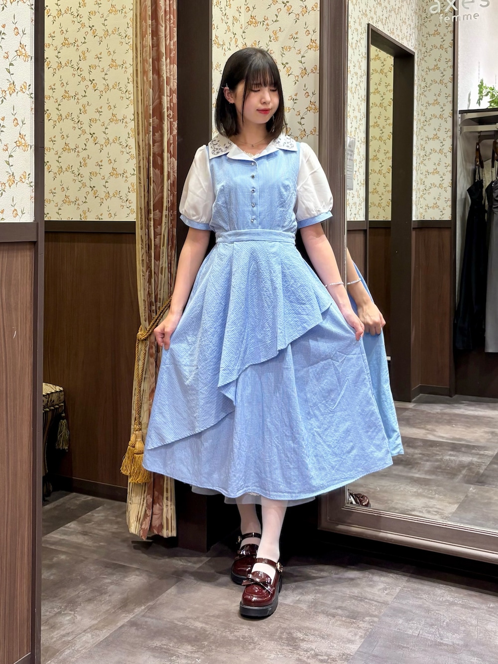 ホワイト系のタンクトップ、ブルー系のワンピース、ブラウン系のボストンバッグを着用したレディースの夏コーディネートの6枚目の写真