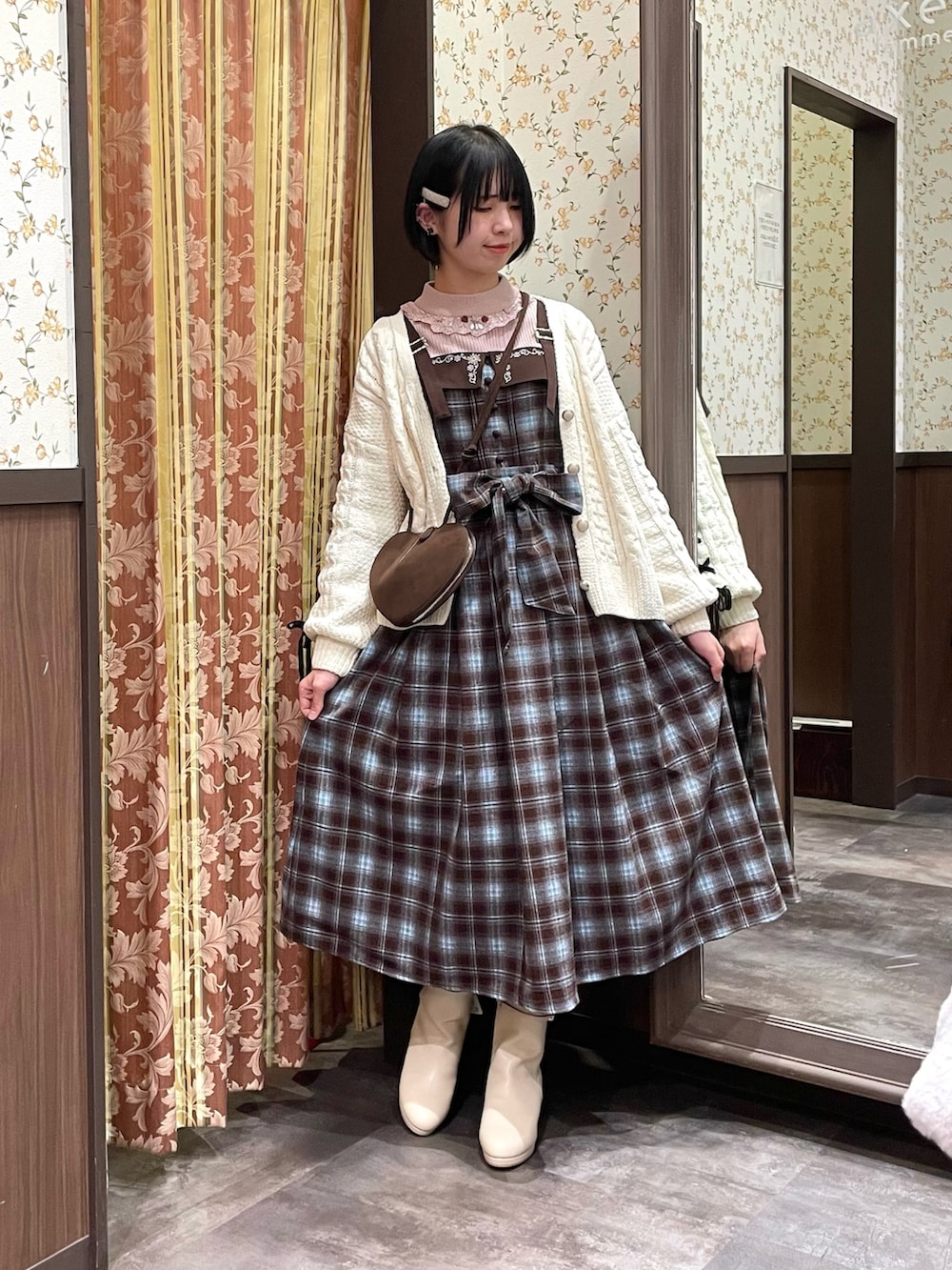 ホワイト系のカーディガン/ボレロ、ブラウン系のジャンパースカート、ピンク系のニット/セーターを着用したレディースの冬コーディネートの2枚目の写真