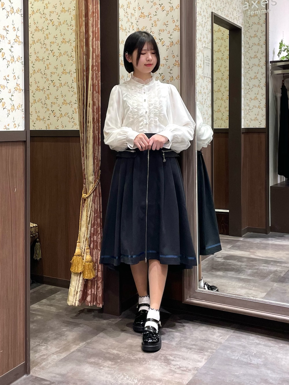 ホワイト系のシャツ/ブラウス、ブラック系のローファー、ブラック系のトレンチコートを着用したレディースの春コーディネートの3枚目の写真