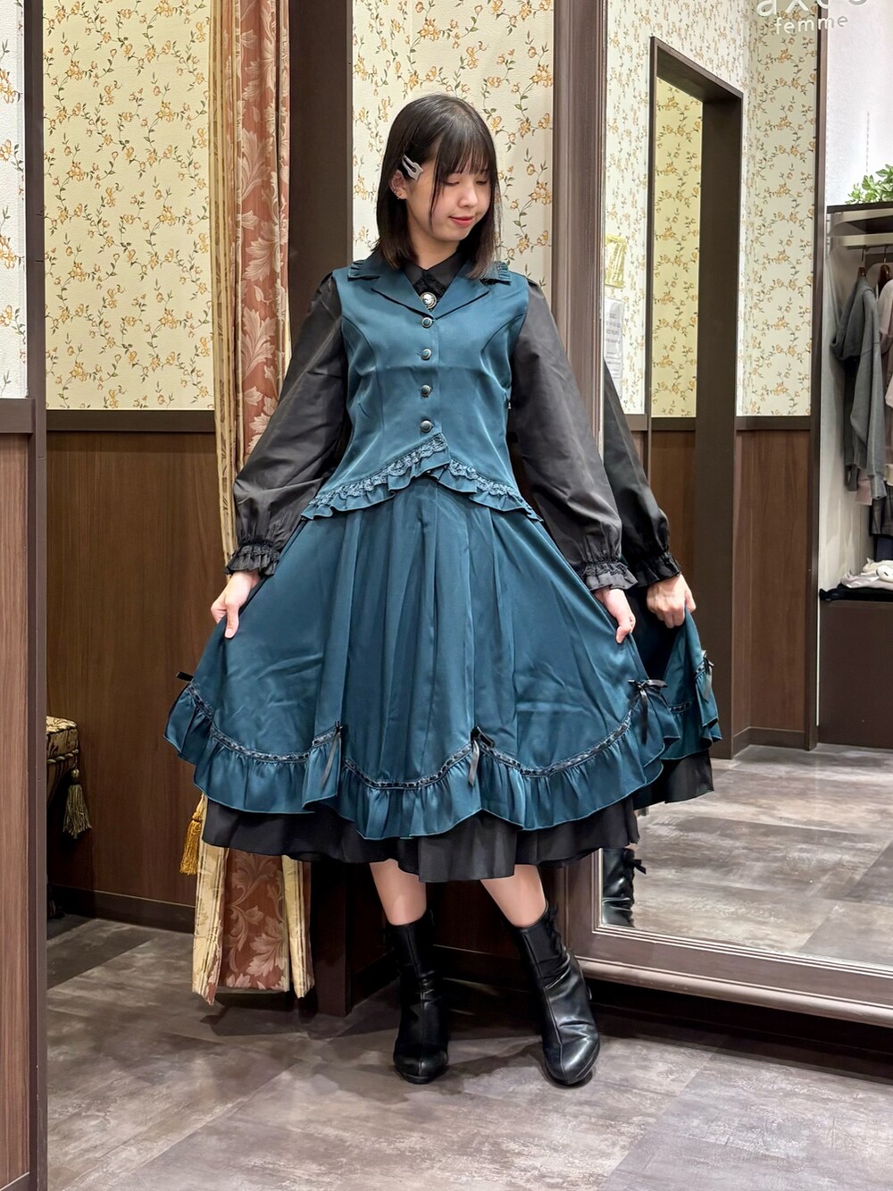 ブラック系のシャツ/ブラウス、ブルー系のベスト、ブルー系のスカートを着用したレディースの夏コーディネートの3枚目の写真