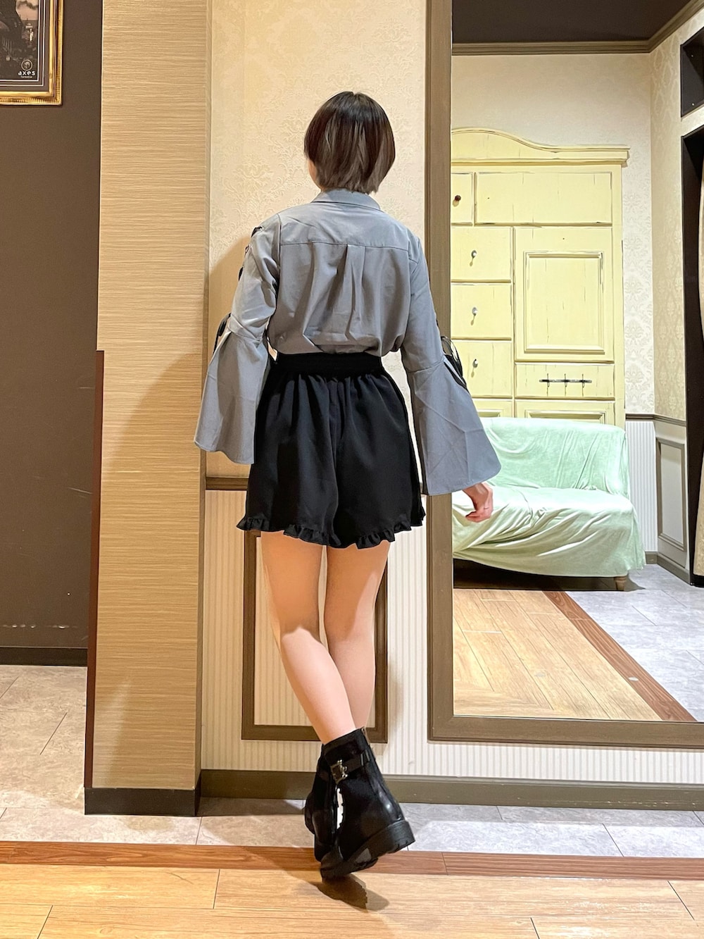 ブラック系のブーツ、グレー系のショルダーバッグ、ホワイト系のタンクトップを着用したレディースの秋コーディネートの4枚目の写真