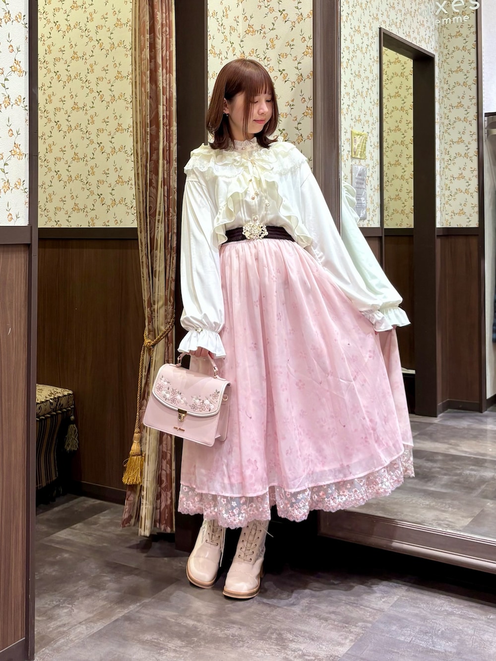 ピンク系のスカート、ベージュ系のブーツ、ピンク系のボストンバッグを着用したレディースの冬コーディネートの3枚目の写真