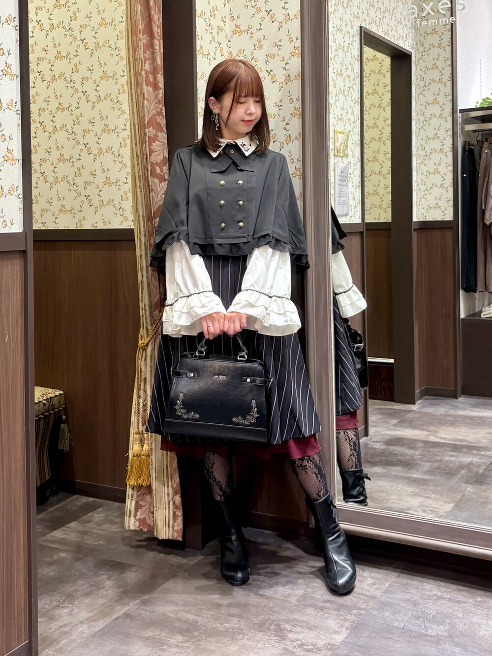 ブルー系のスカート、ブラック系のベスト、ホワイト系のシャツ/ブラウスを着用したレディースの秋コーディネートの3枚目の写真