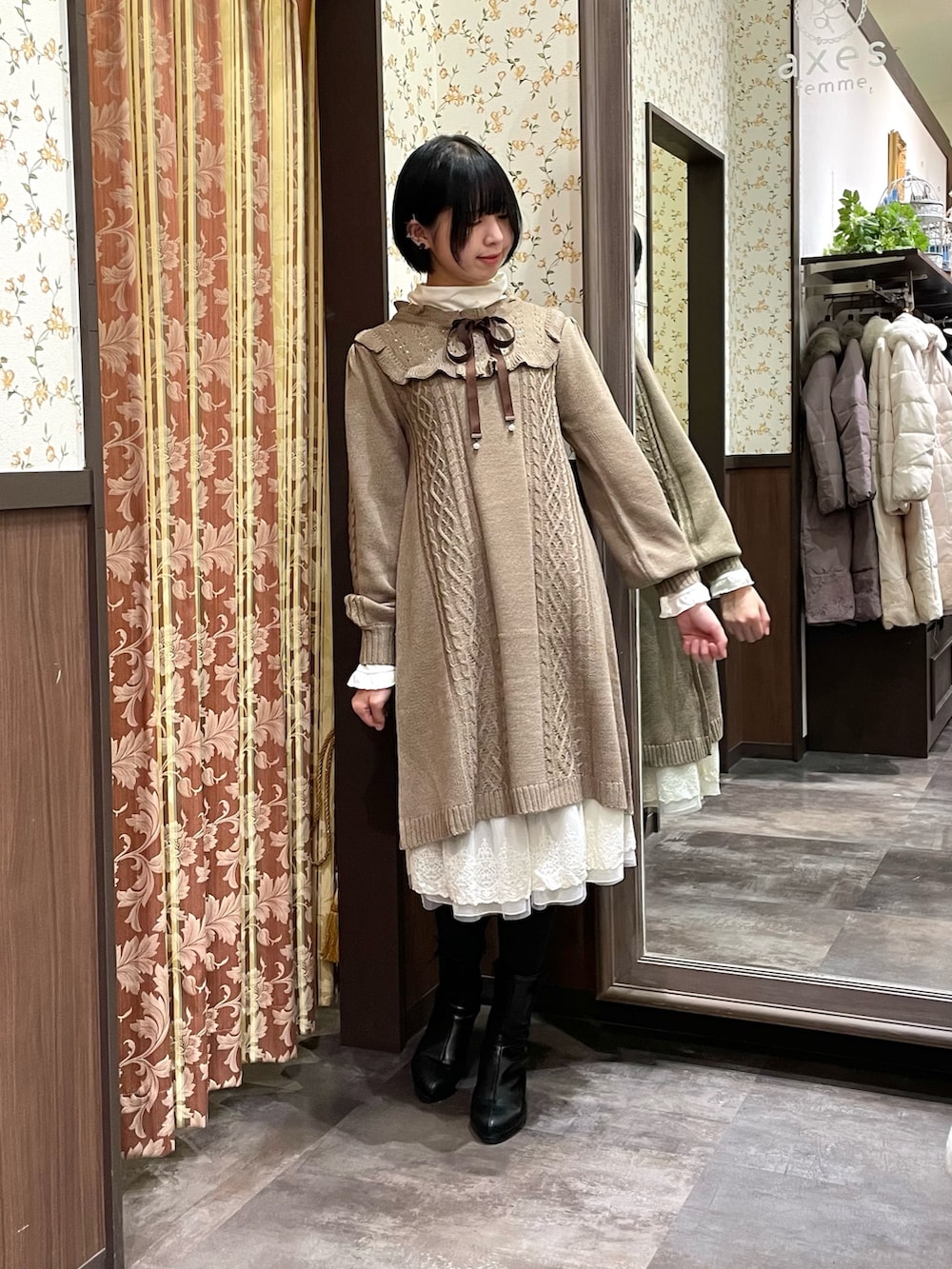 ホワイト系のその他アウター、ブラウン系のワンピース、ブラック系のブーツを着用したレディースの冬コーディネートの4枚目の写真