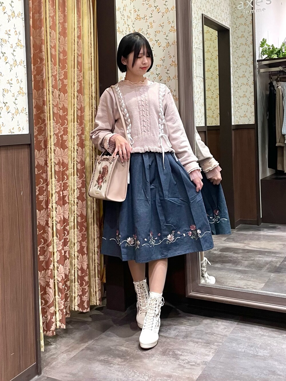 ピンク系のTシャツ/カットソー、ピンク系のニット/セーター、ブルー系のスカートを着用したレディースの冬コーディネートの4枚目の写真