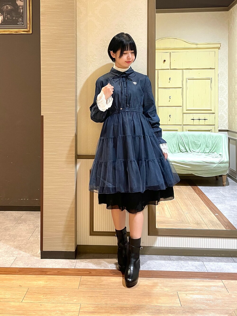 ホワイト系のピーコート、ブルー系のワンピース、ブラック系のブーツを着用したレディースの秋コーディネートの7枚目の写真