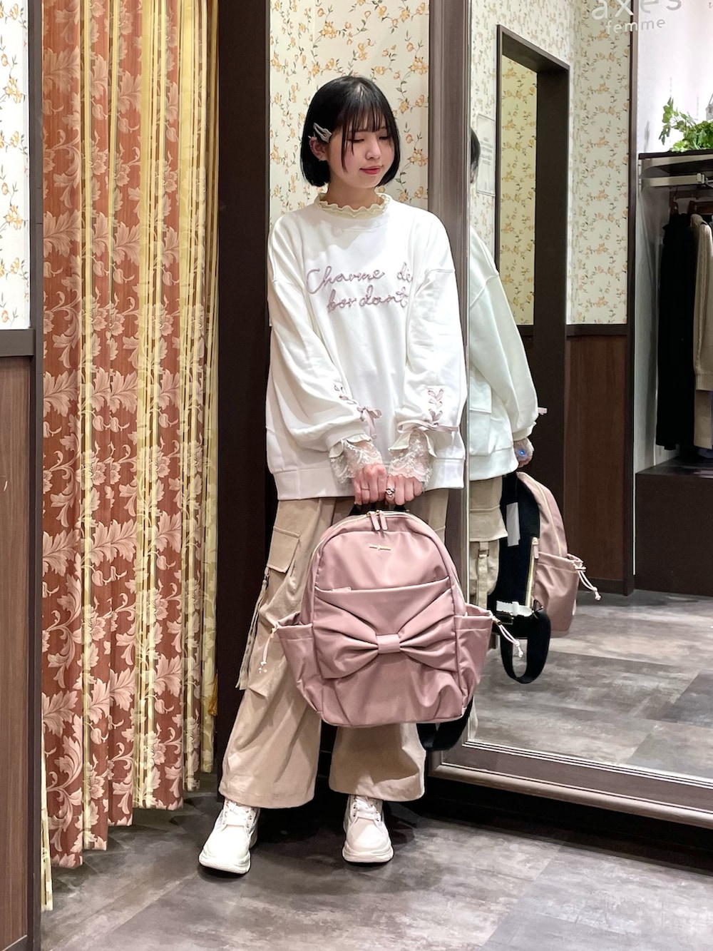 ピンク系のバックパック/リュック、ベージュ系のカーゴパンツ、ホワイト系のスニーカーを着用したレディースの春コーディネートの2枚目の写真