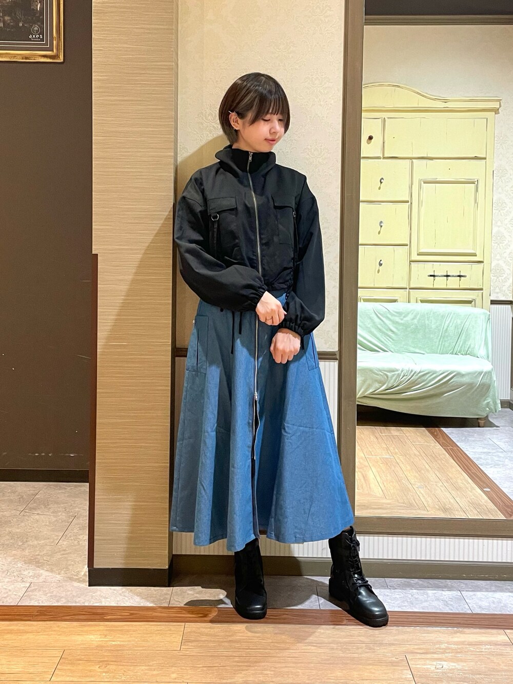 ブルー系のジャンパースカート、ブラック系のブーツを着用したレディースの秋コーディネートの6枚目の写真