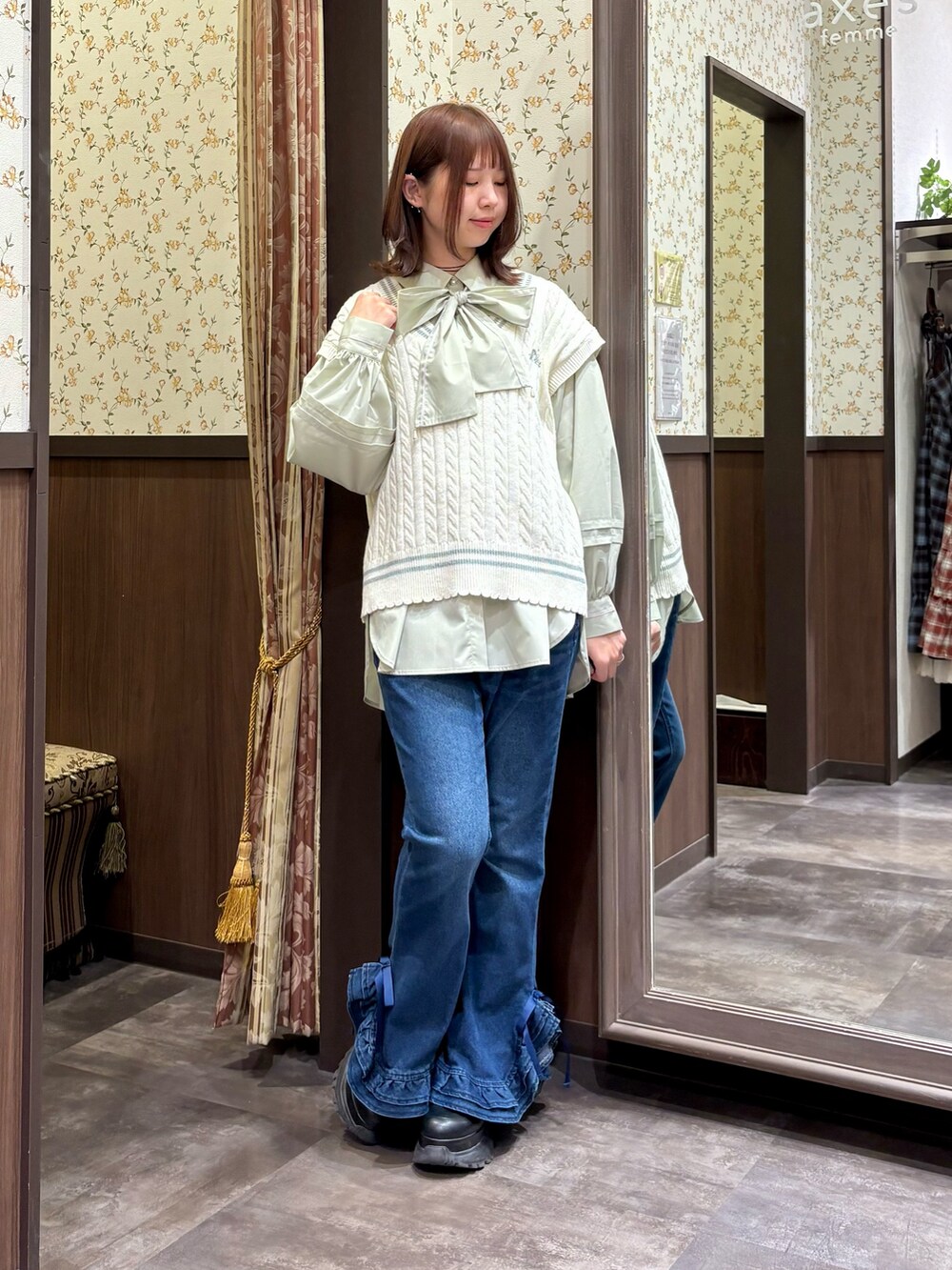 グリーン系のシャツ/ブラウス、ホワイト系のベスト、グリーン系のボストンバッグを着用したレディースの冬コーディネートの3枚目の写真
