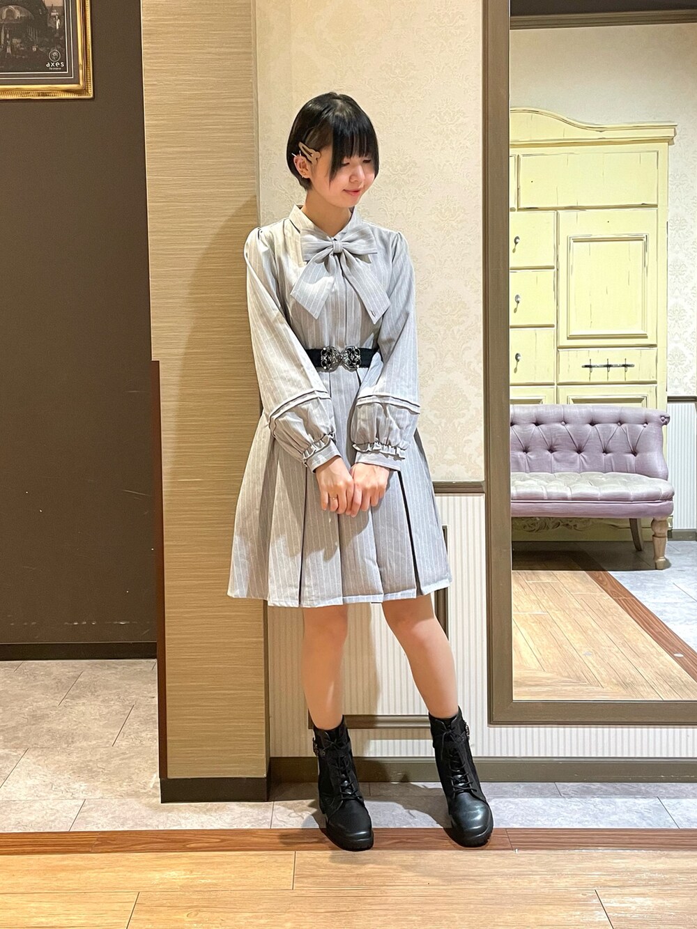 グレー系のワンピース、ブラック系のショルダーバッグ、ブラック系のブーツを着用したレディースの秋コーディネートの5枚目の写真