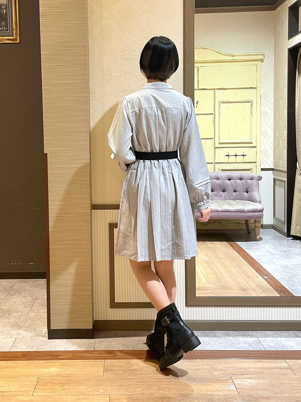 グレー系のワンピース、ブラック系のショルダーバッグ、ブラック系のブーツを着用したレディースの秋コーディネートの7枚目の写真