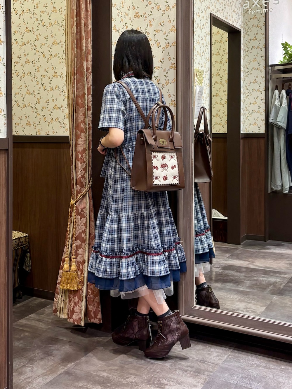 ホワイト系のタンクトップ、ブルー系のワンピース、ブラウン系のボストンバッグを着用したレディースの夏コーディネートの3枚目の写真