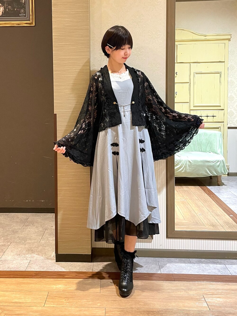 ホワイト系のタンクトップ、ブラック系のブーツ、ブラック系のボストンバッグを着用したレディースの夏コーディネートの2枚目の写真