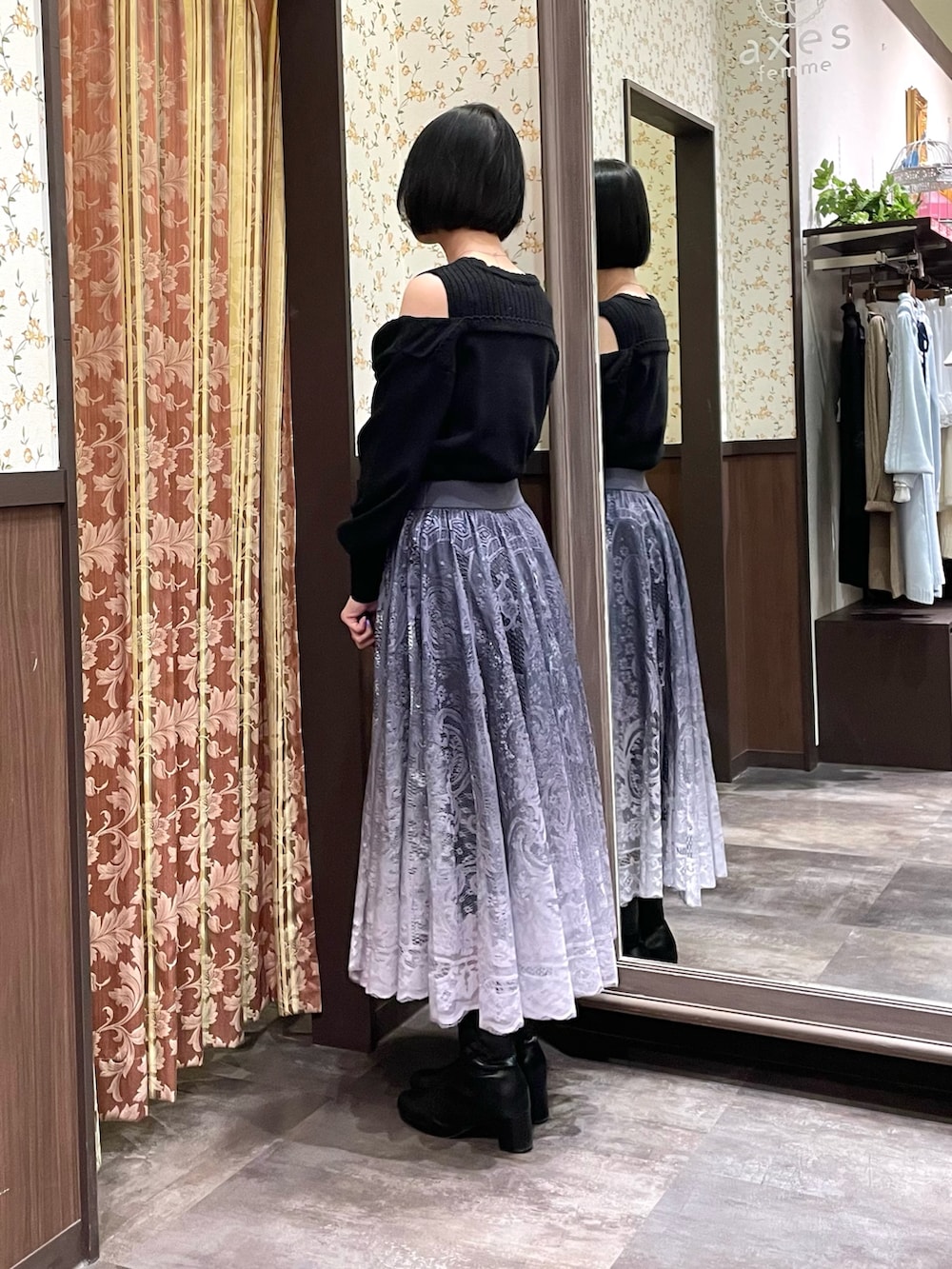 ブラック系のニット/セーター、グレー系のスカート、ブラック系のブーツを着用したレディースの冬コーディネートの3枚目の写真