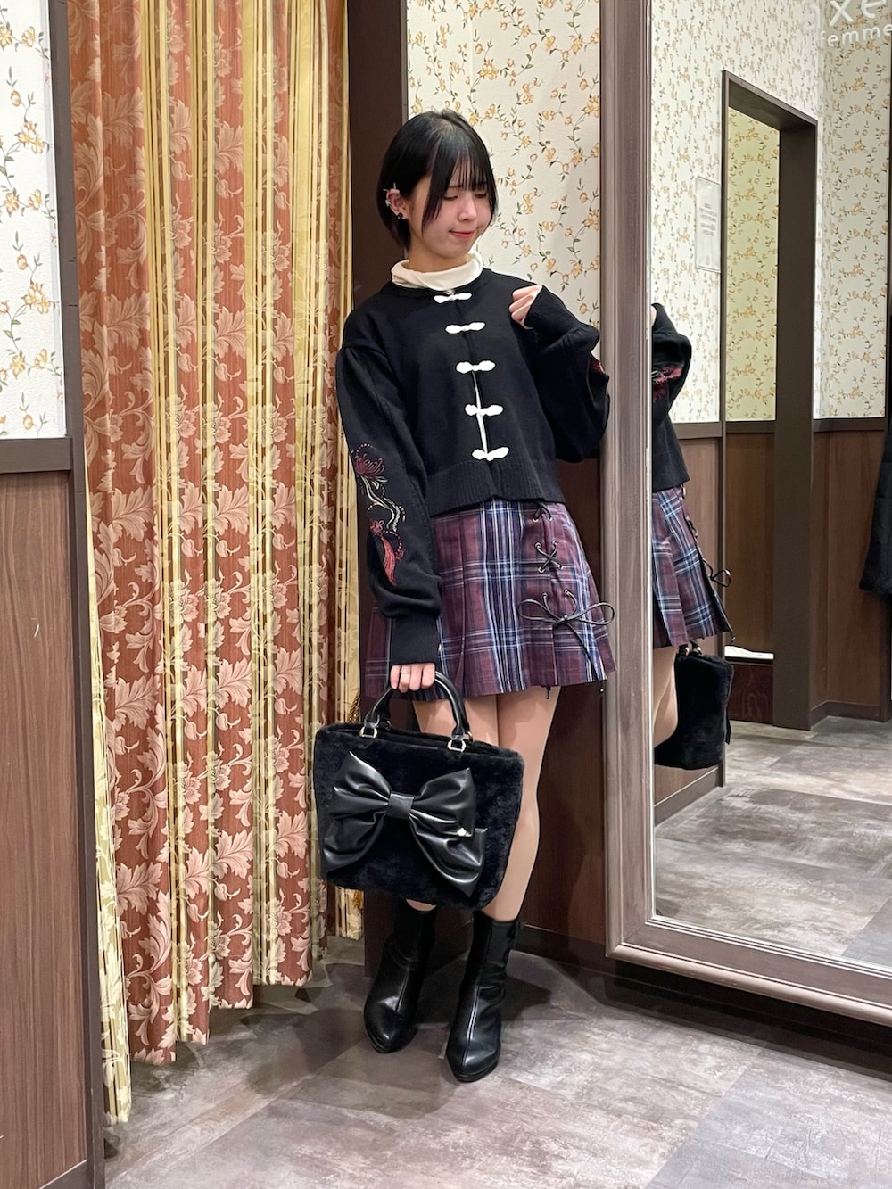 レッド系のその他パンツ、ブラック系のカーディガン/ボレロ、ブラック系のブーツを着用したレディースの冬コーディネートの2枚目の写真