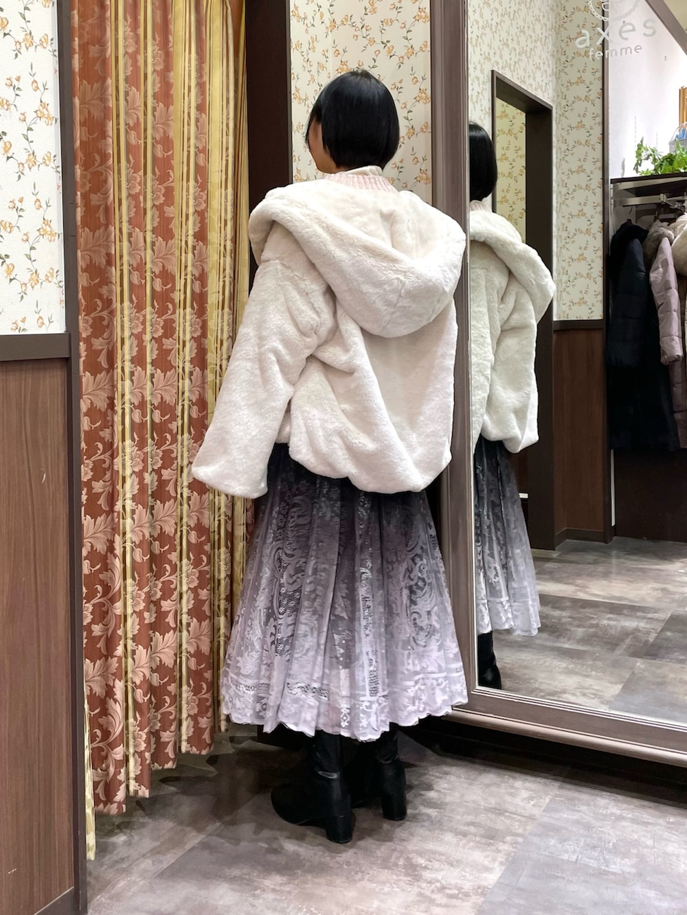 ホワイト系のダッフルコート、ピンク系のニット/セーター、ブラウン系のスカートを着用したレディースの冬コーディネートの4枚目の写真