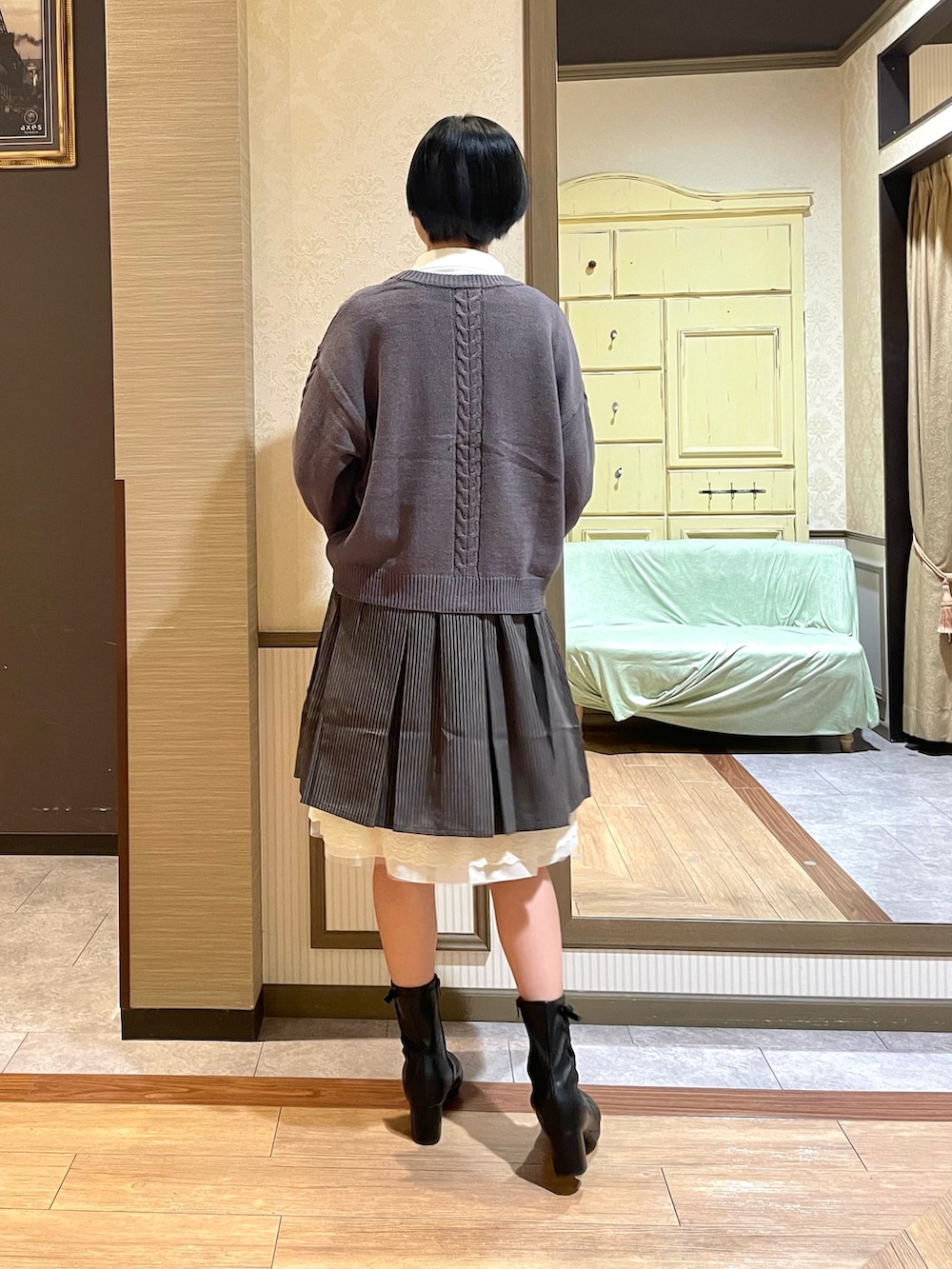 ブラック系のショルダーバッグ、ブラック系のブーツ、グレー系のカーディガン/ボレロを着用したレディースの秋コーディネートの3枚目の写真