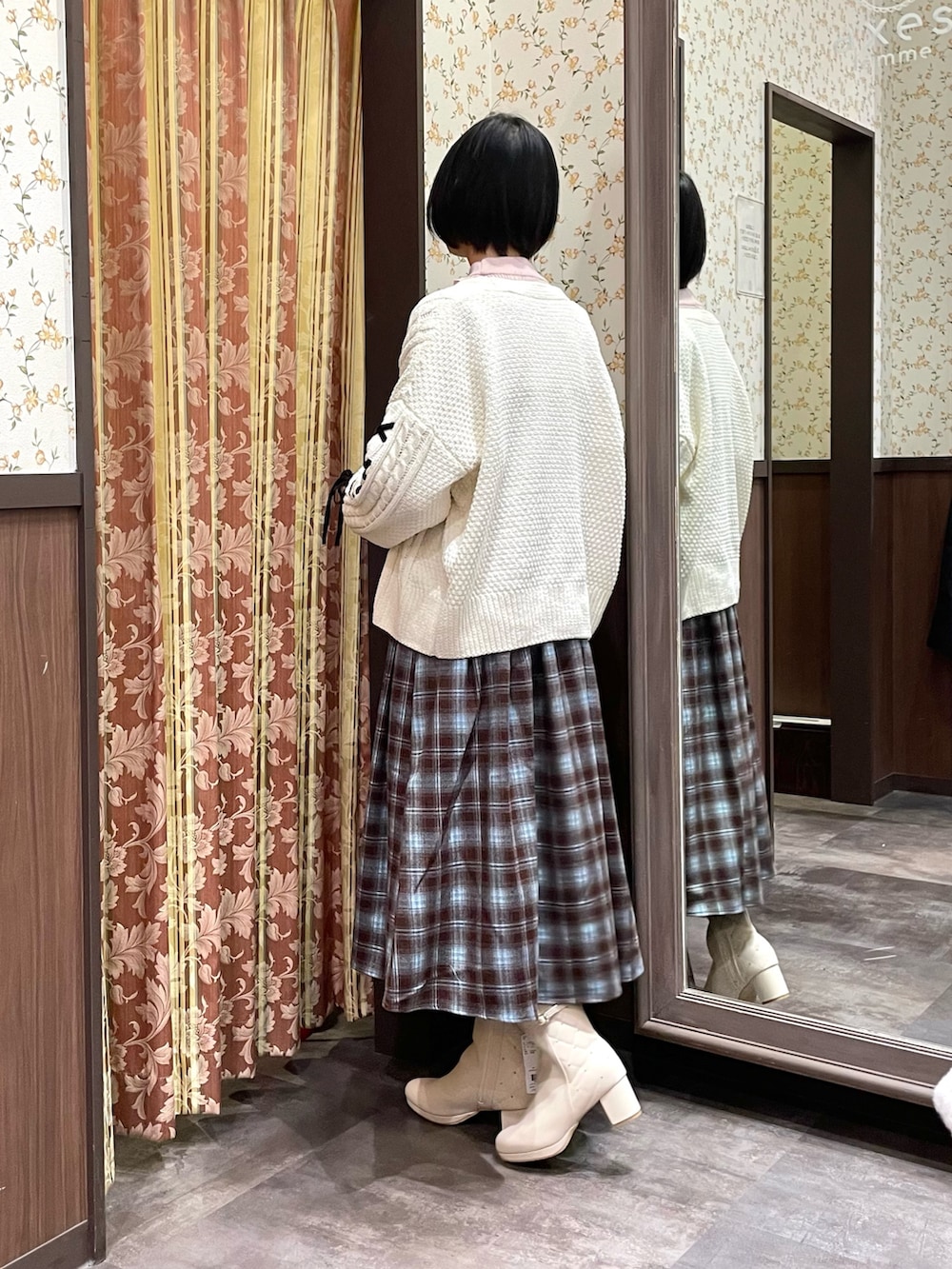 ホワイト系のカーディガン/ボレロ、ブラウン系のジャンパースカート、ピンク系のニット/セーターを着用したレディースの冬コーディネートの6枚目の写真