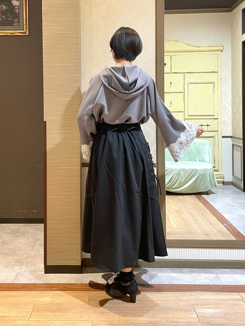 ブラック系のブーツ、ブラック系のトートバッグ、ホワイト系のタンクトップを着用したレディースの夏コーディネートの5枚目の写真