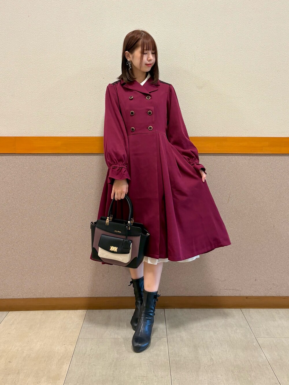 レッド系のトレンチコート、ホワイト系のシャツ/ブラウス、ブラック系のスカートを着用したレディースの秋コーディネートの6枚目の写真