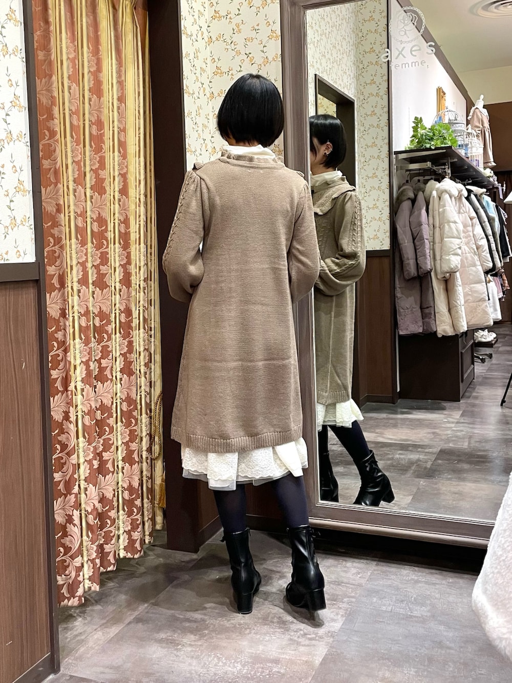 ホワイト系のその他アウター、ブラウン系のワンピース、ブラック系のブーツを着用したレディースの冬コーディネートの6枚目の写真