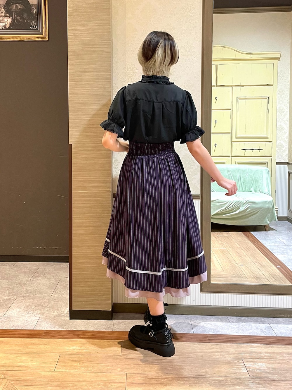 ホワイト系のタンクトップ、ブラック系のパンプス、ブラック系のボストンバッグを着用したレディースの夏コーディネートの6枚目の写真