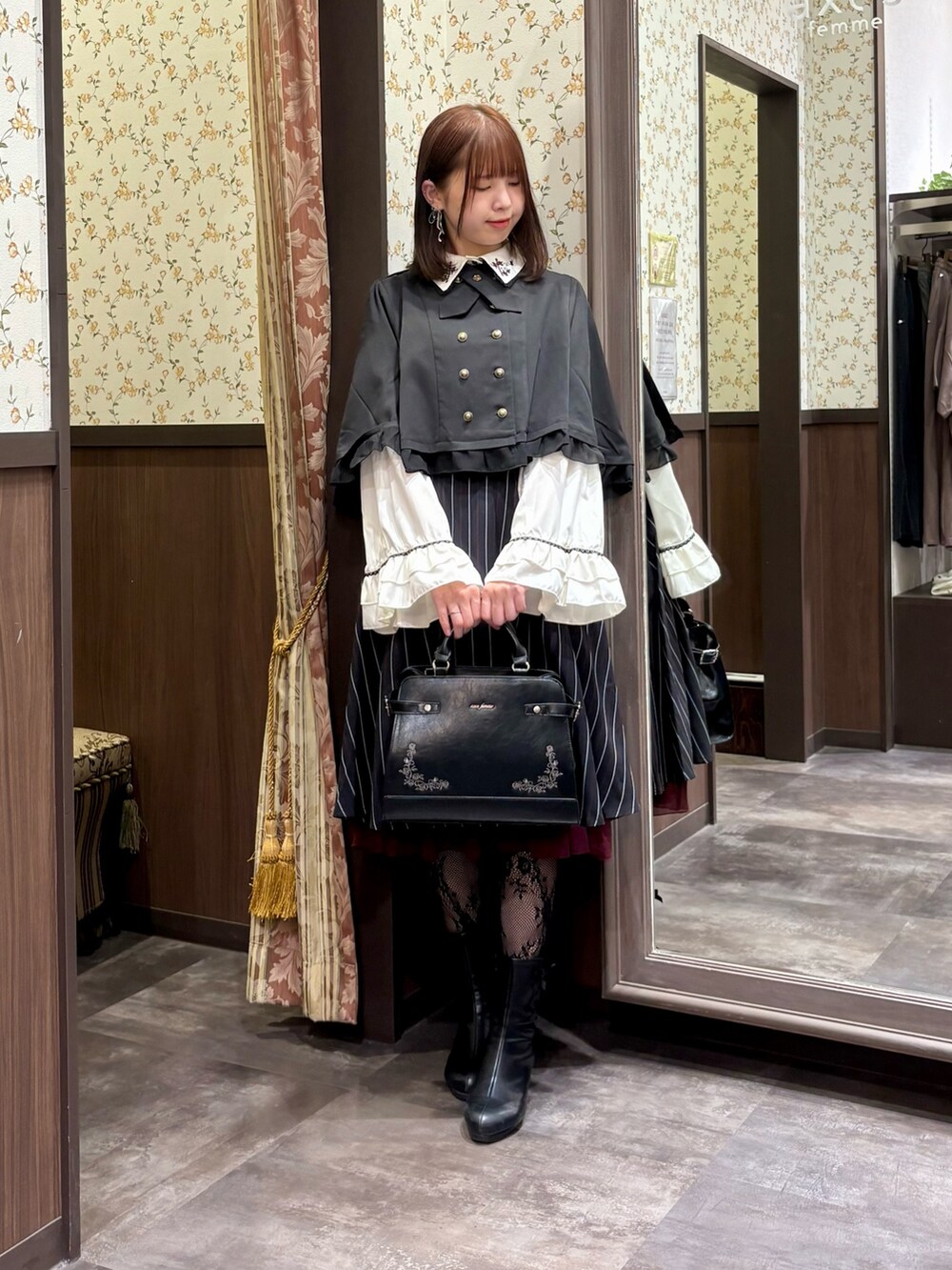 ブルー系のスカート、ブラック系のベスト、ホワイト系のシャツ/ブラウスを着用したレディースの秋コーディネートの4枚目の写真