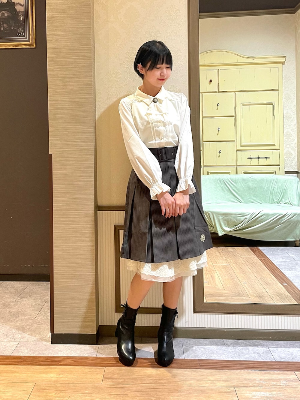 ブラック系のショルダーバッグ、ブラック系のブーツ、グレー系のカーディガン/ボレロを着用したレディースの秋コーディネートの5枚目の写真