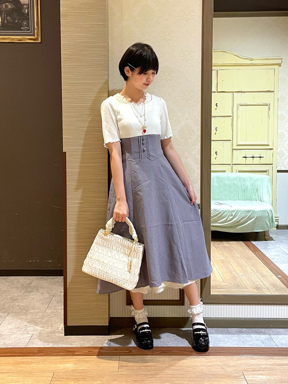 ホワイト系のタンクトップ、ホワイト系のショルダーバッグ、パープル系のワンピースを着用したレディースの夏コーディネートの3枚目の写真