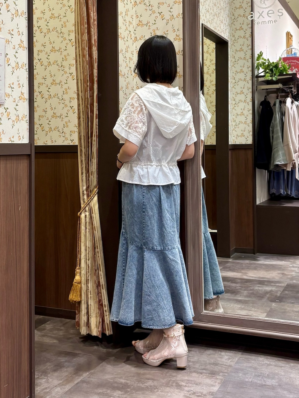 ホワイト系のカーディガン/ボレロ、レッド系のタンクトップ、ブルー系のデニムスカートを着用したレディースの春コーディネートの5枚目の写真