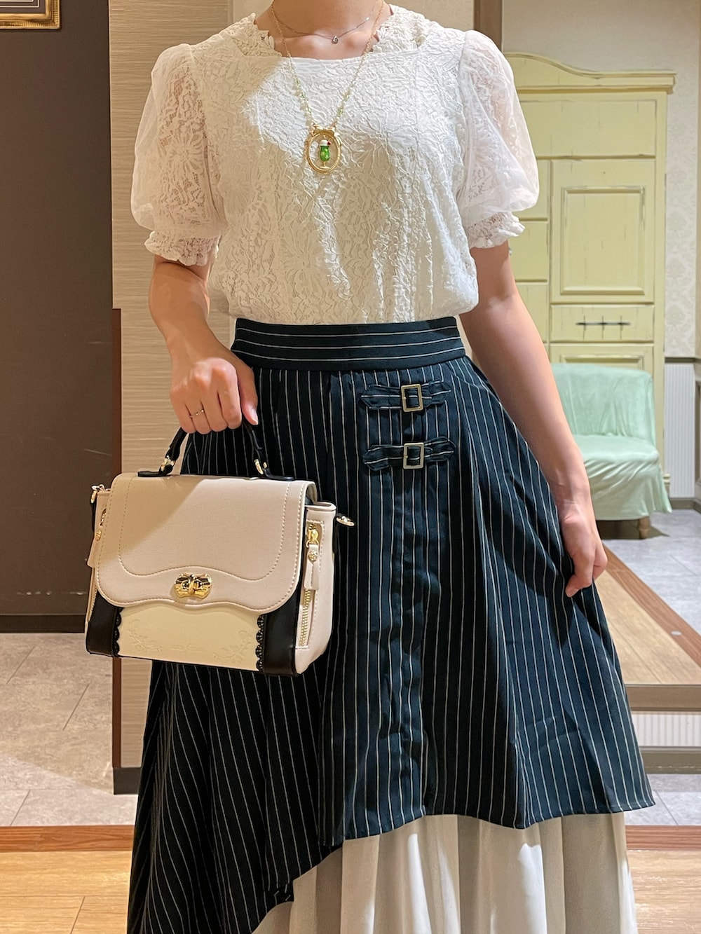 ホワイト系のサンダル、ベージュ系のショルダーバッグ、ホワイト系のタンクトップを着用したレディースの夏コーディネートの2枚目の写真