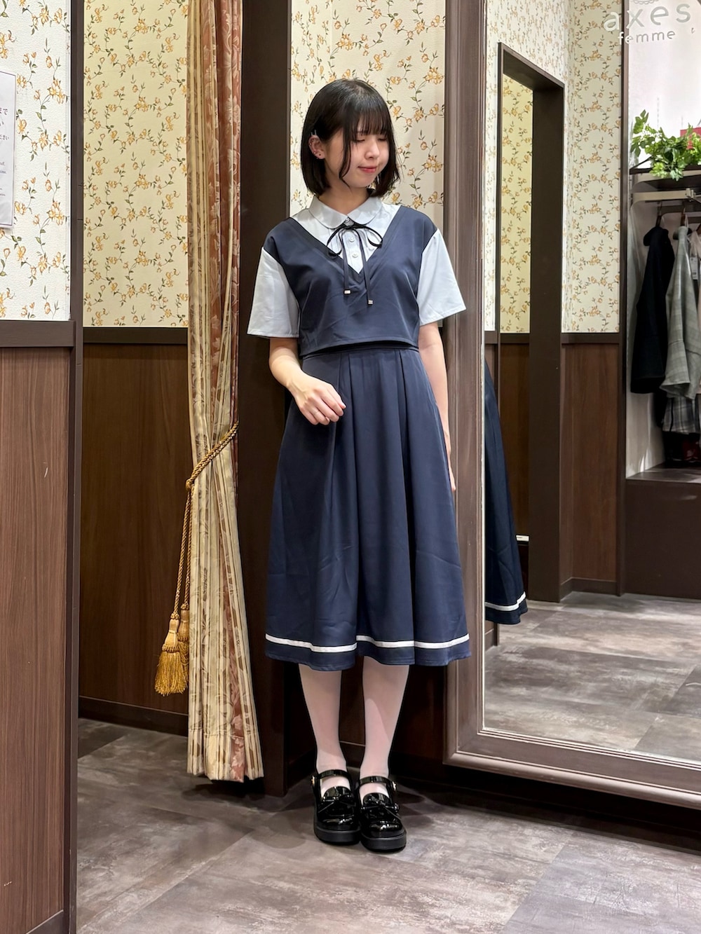 ブラック系のローファー、ブルー系のワンピース、ブルー系のタンクトップを着用したレディースの春コーディネートの4枚目の写真