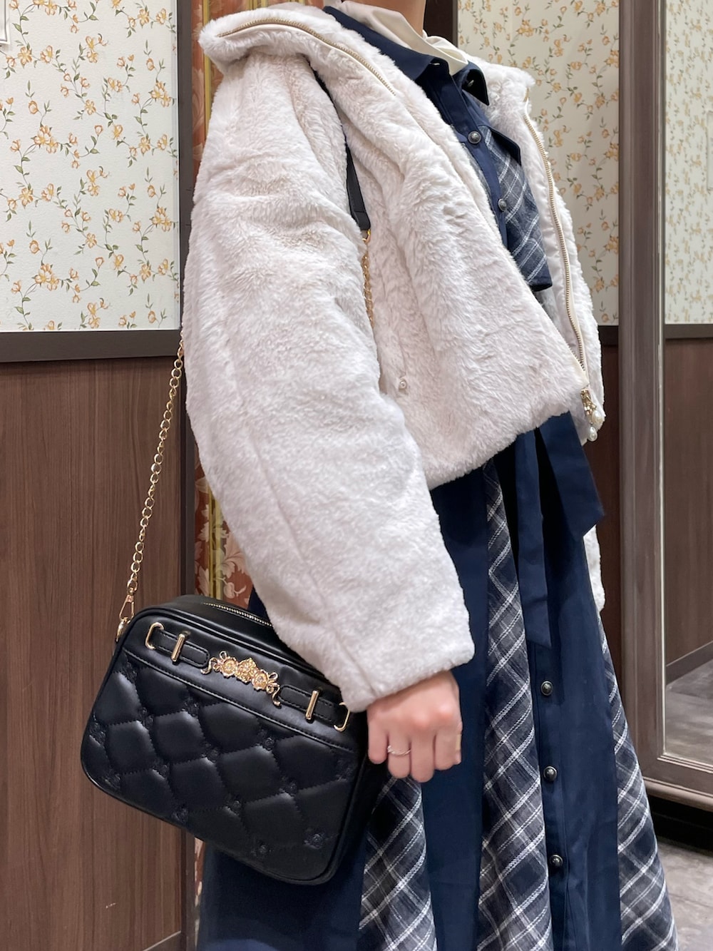 ホワイト系のピーコート、ブルー系のワンピース、ブラック系のブーツを着用したレディースの冬コーディネートの3枚目の写真