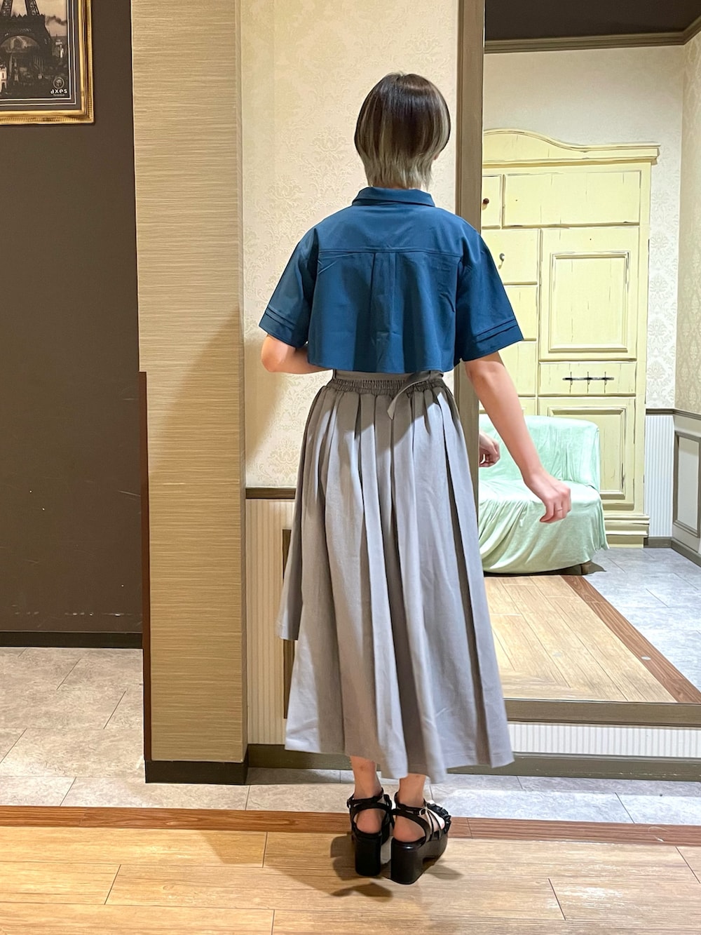 ホワイト系のタンクトップ、ブラック系のショルダーバッグ、グレー系のスカートを着用したレディースの夏コーディネートの4枚目の写真