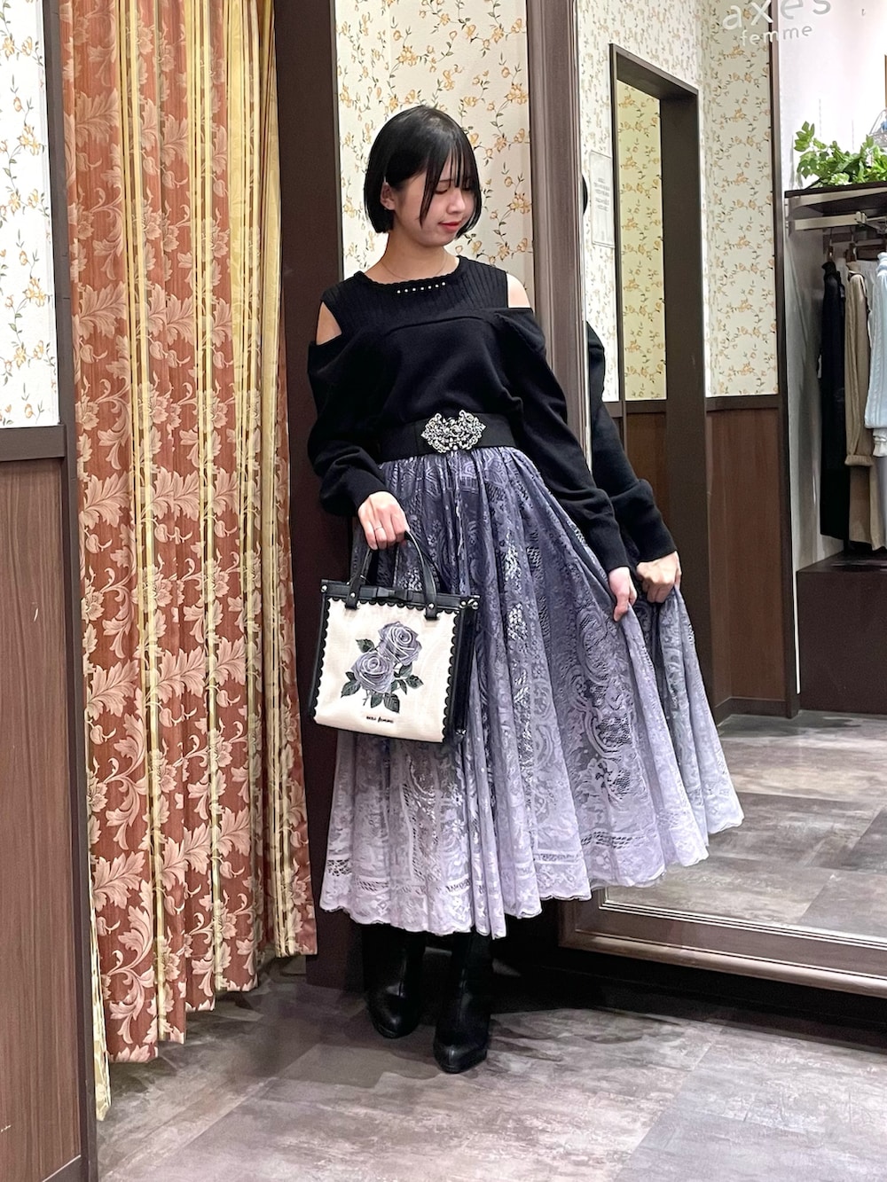 ブラック系のニット/セーター、グレー系のスカート、ブラック系のブーツを着用したレディースの冬コーディネートの5枚目の写真