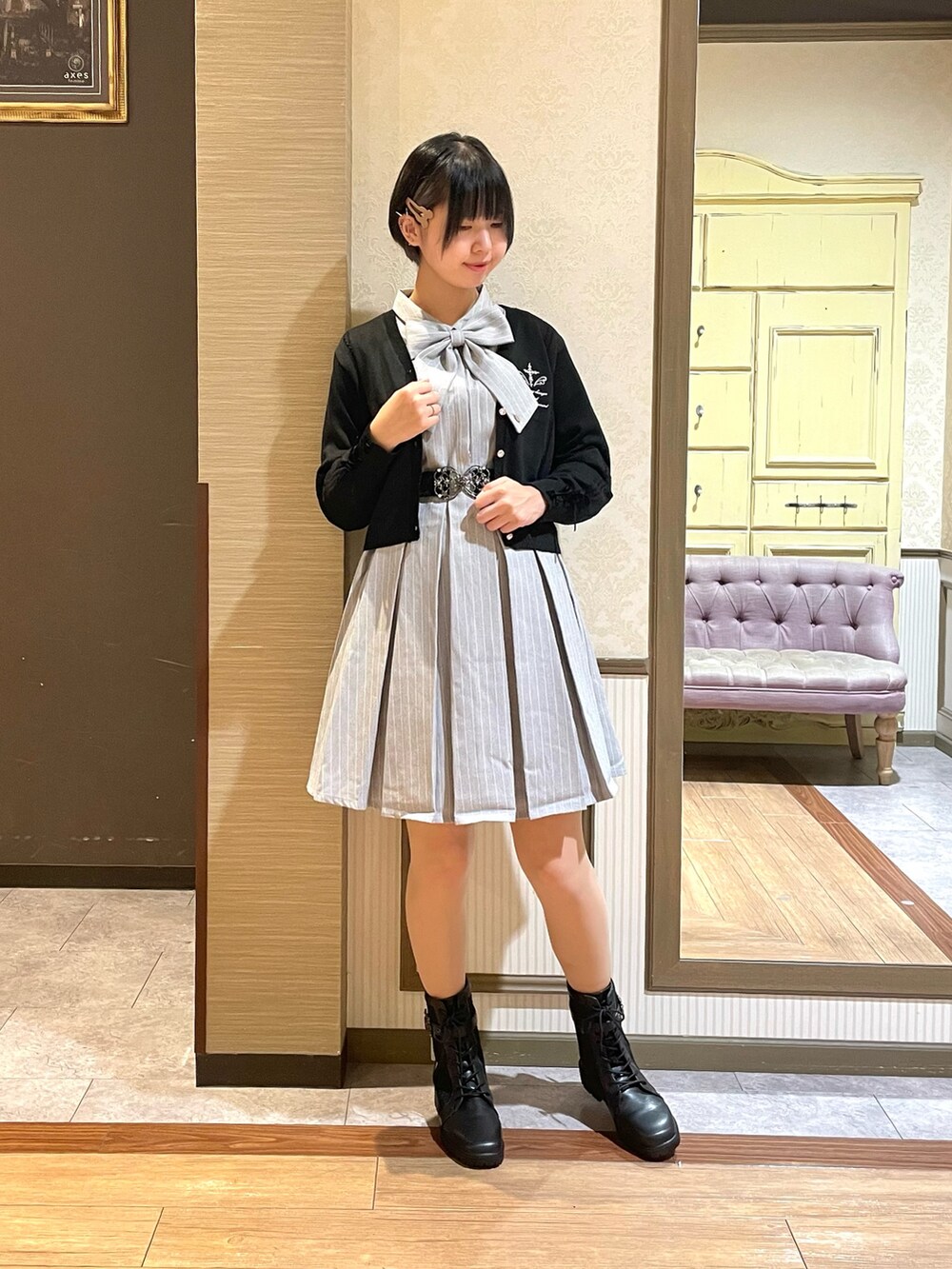 グレー系のワンピース、ブラック系のショルダーバッグ、ブラック系のブーツを着用したレディースの秋コーディネートの2枚目の写真