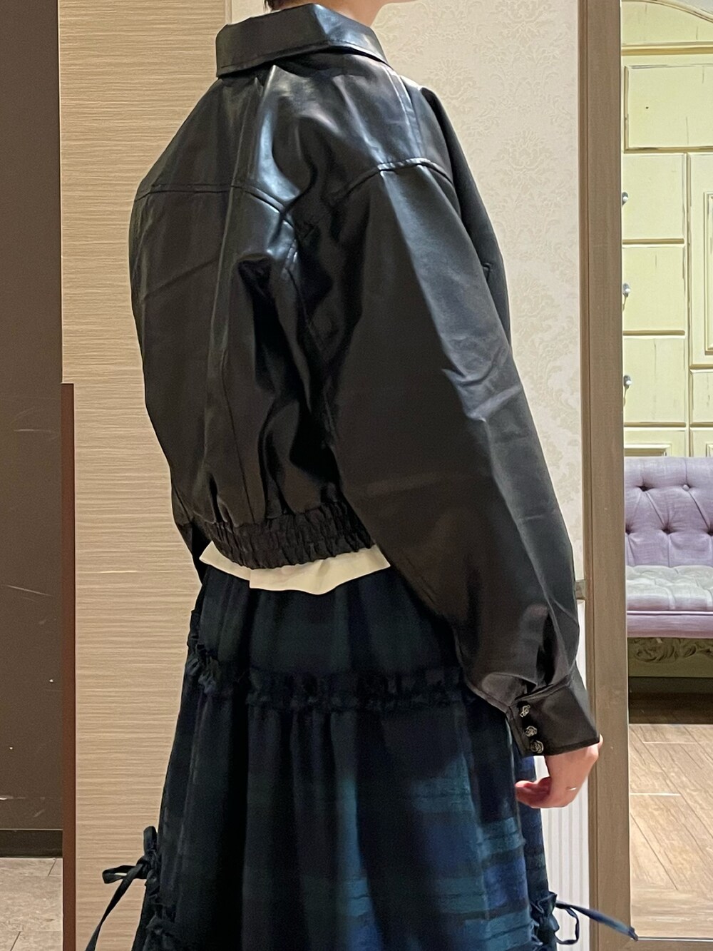 ブラック系のショルダーバッグ、ブラック系のブーツ、グリーン系のスカートを着用したレディースの秋コーディネートの7枚目の写真