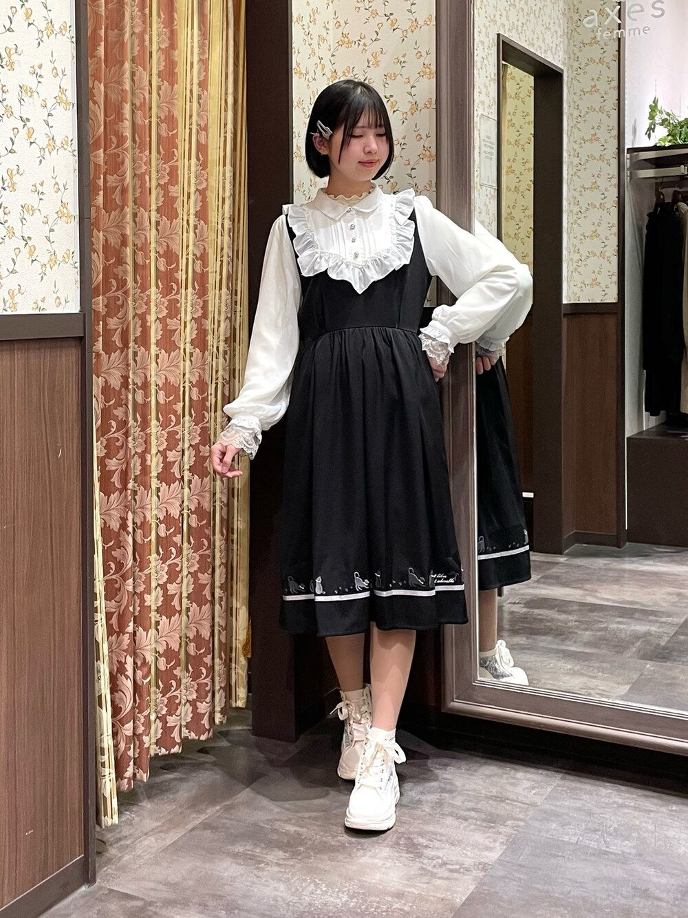 ホワイト系のスニーカー、ブラック系のワンピース、ブラック系のショルダーバッグを着用したレディースの春コーディネートの6枚目の写真