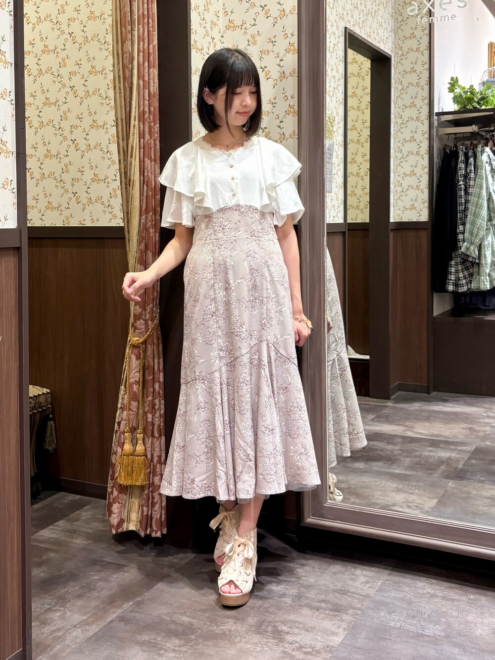 ベージュ系のワンピース、ホワイト系のタンクトップ、ベージュ系のショルダーバッグを着用したレディースの夏コーディネートの2枚目の写真