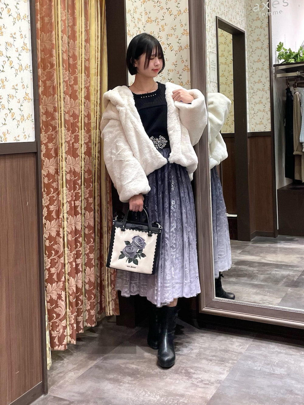 ブラック系のニット/セーター、グレー系のスカート、ブラック系のブーツを着用したレディースの冬コーディネートの4枚目の写真