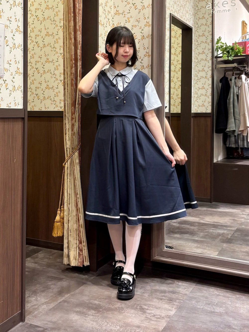 ブラック系のローファー、ブルー系のワンピース、ブルー系のタンクトップを着用したレディースの春コーディネートの2枚目の写真