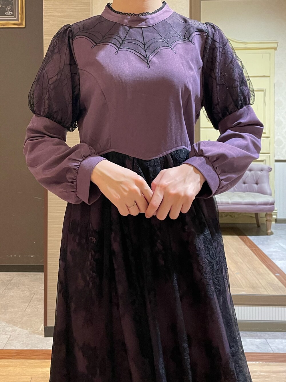 ブラック系のテーラードジャケット、パープル系のワンピース、ブラック系のブーツを着用したレディースの秋コーディネートの7枚目の写真