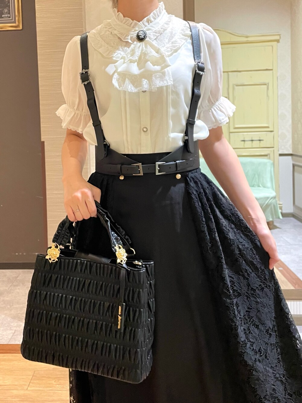 ブラック系のショルダーバッグ、ブラック系のブーツ、ブラック系のスカートを着用したレディースの夏コーディネートの4枚目の写真