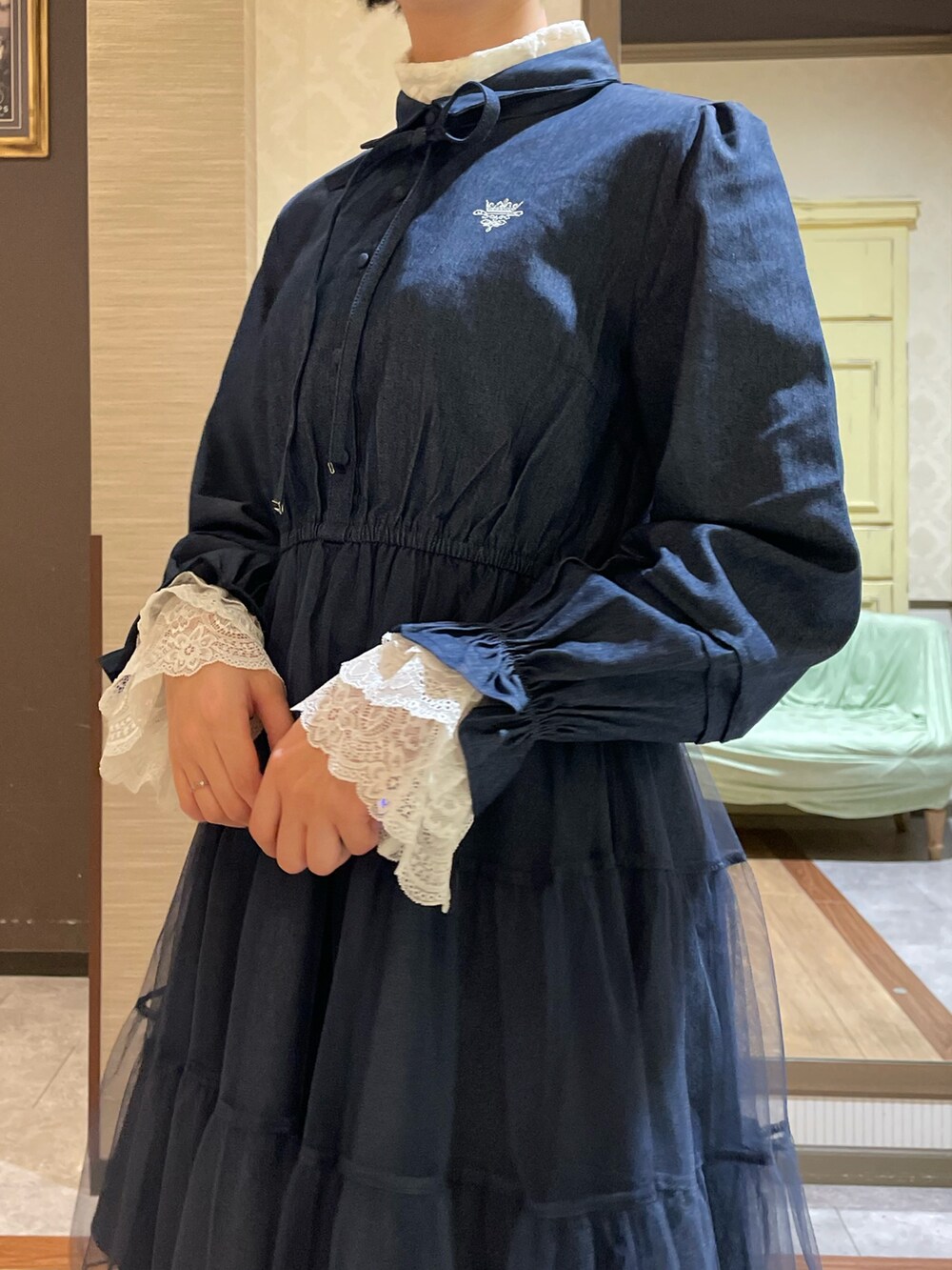 ホワイト系のピーコート、ブルー系のワンピース、ブラック系のブーツを着用したレディースの秋コーディネートの8枚目の写真