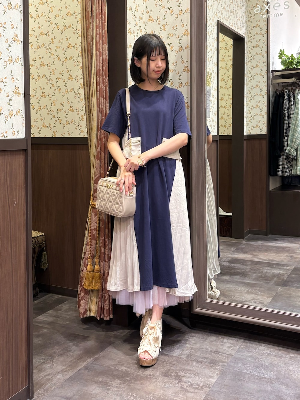 ホワイト系のタンクトップ、ブルー系のワンピース、ホワイト系のスカートを着用したレディースの夏コーディネートの3枚目の写真